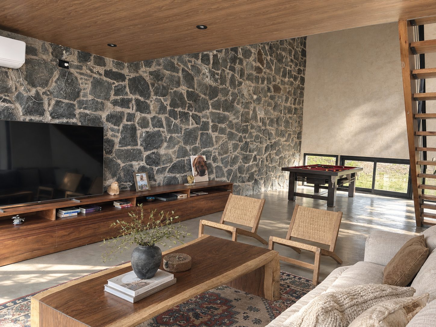 Casa de piedra en la sierra, Vivienda con muro de piedra, escalera de madera y vistas a la sierra