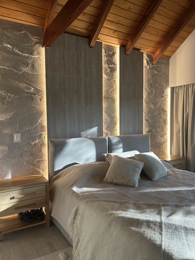 Dormitorio con techo de madera y muro de piedra, Remodelación en Jockey Club